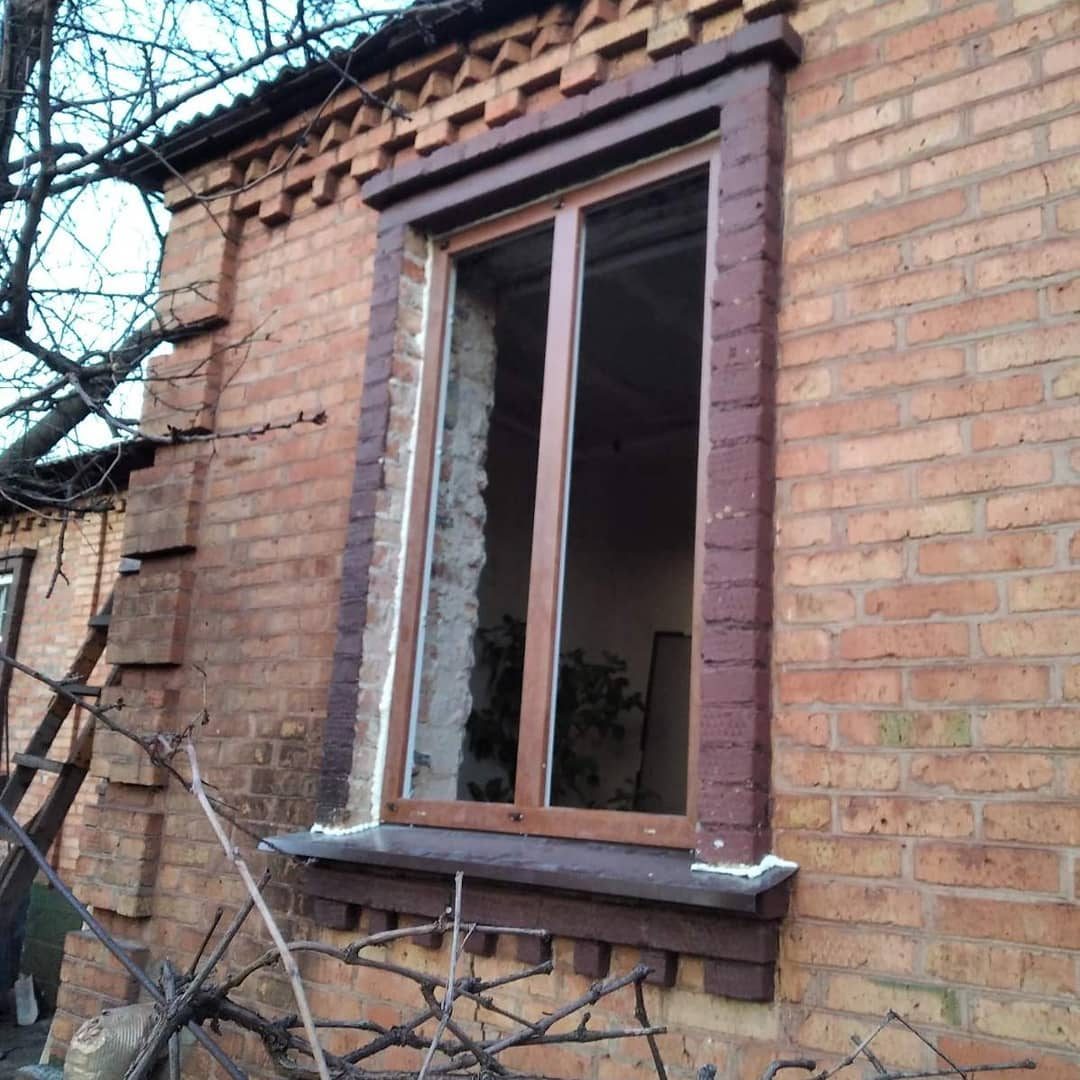 Високе вікно в цегляній стіні приватного будинку