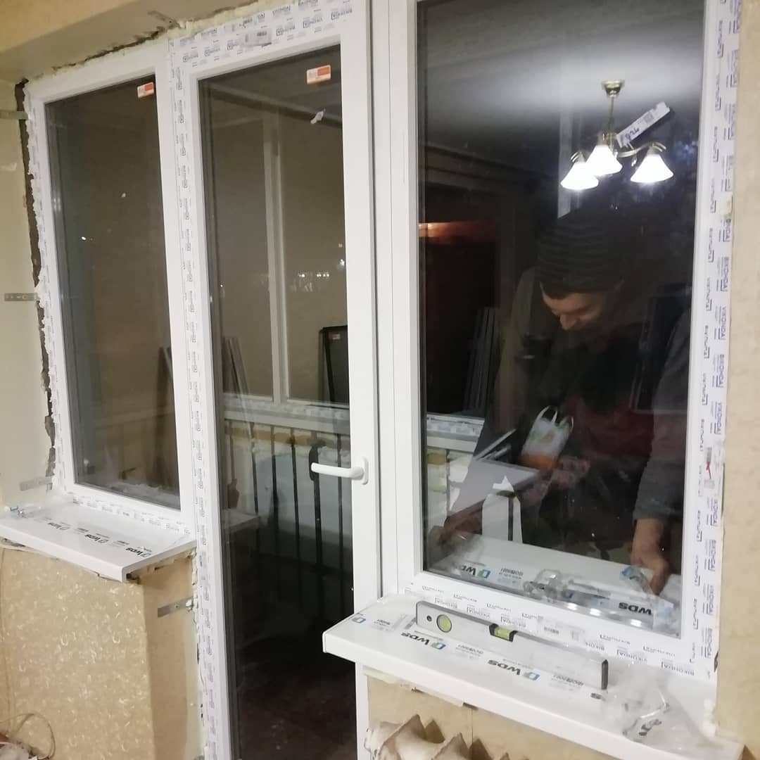 Монтаж пластикового вікна: майстер кріпить раму в прорізі, Кривий Ріг